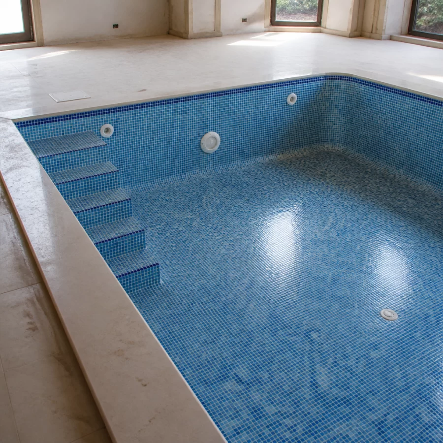 Mặt trong hồ bơi đang thi công với gạch mosaic và lớp nền cần keo dán chuyên dụng.