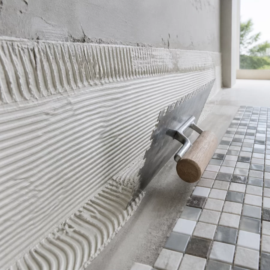 Thi công gạch mosaic bằng keo dán chuyên dụng trên bề mặt đã xử lý phẳng.