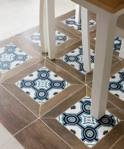 Gạch bông Novita NLB DC 30x60 lát sàn phòng ăn nhỏ, cận cảnh bề mặt vân gỗ kết hợp hoa văn xanh-trắng, không gian bàn ghế đơn giản, nền sáng rõ, chân thật.